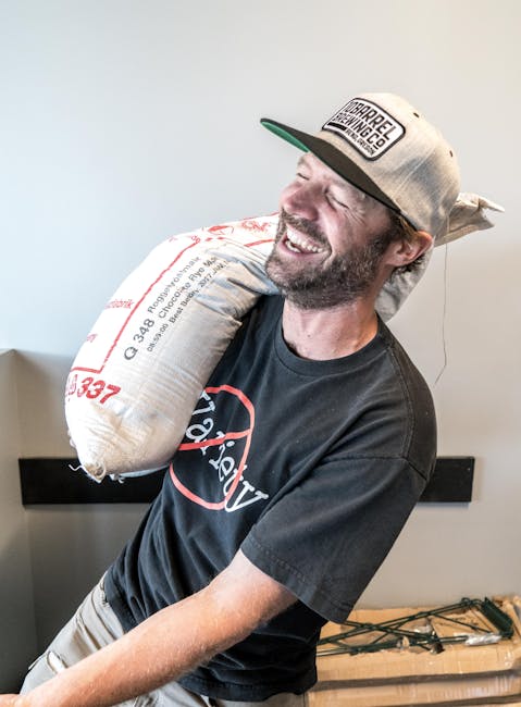 Man Carrying Sack Near White Wall